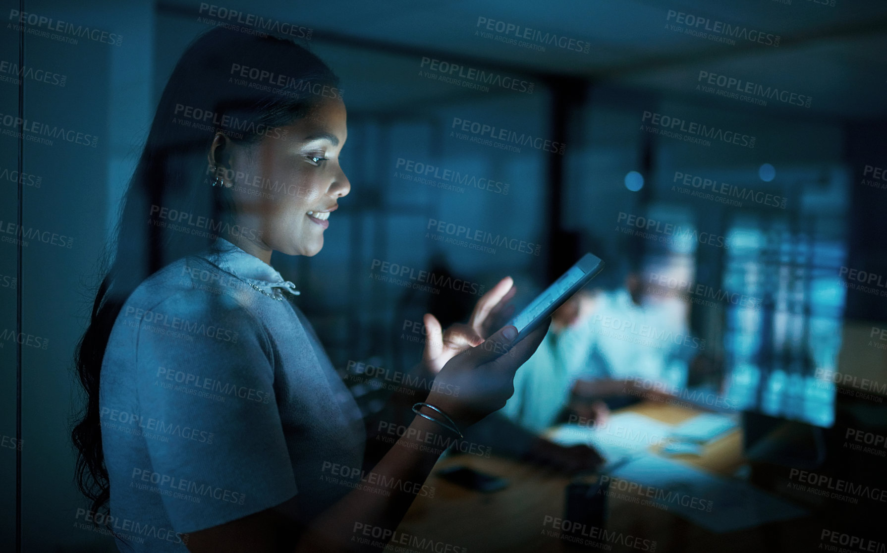Buy stock photo Shot of a young businesswoman using a digital tablet during a late night at work