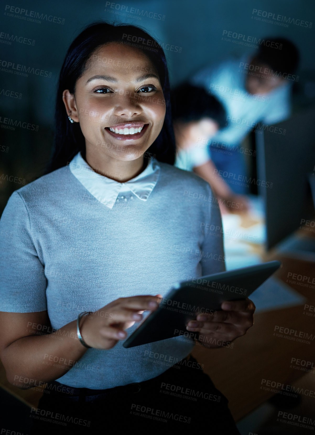 Buy stock photo Shot of a young businesswoman using a digital tablet during a late night at work