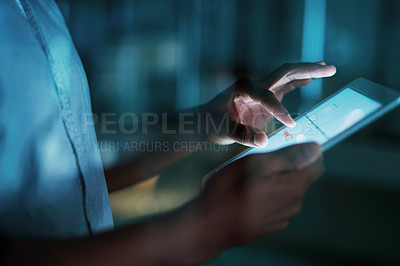 Buy stock photo Shot of an unrecognisable businesswoman using a digital tablet during a late night at work