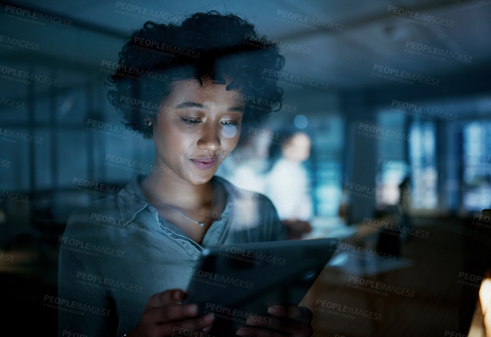 Buy stock photo Shot of a young businesswoman using a digital tablet during a late night at work