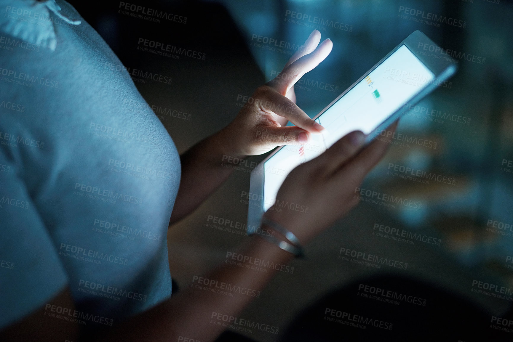 Buy stock photo Shot of an unrecognisable businesswoman using a digital tablet during a late night at work