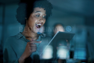 Buy stock photo Shot of a young businesswoman using a digital tablet and looking surprised during a late night at work
