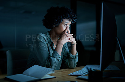 Buy stock photo Shot of a young businesswoman looking stressed while using a computer during a late night at work