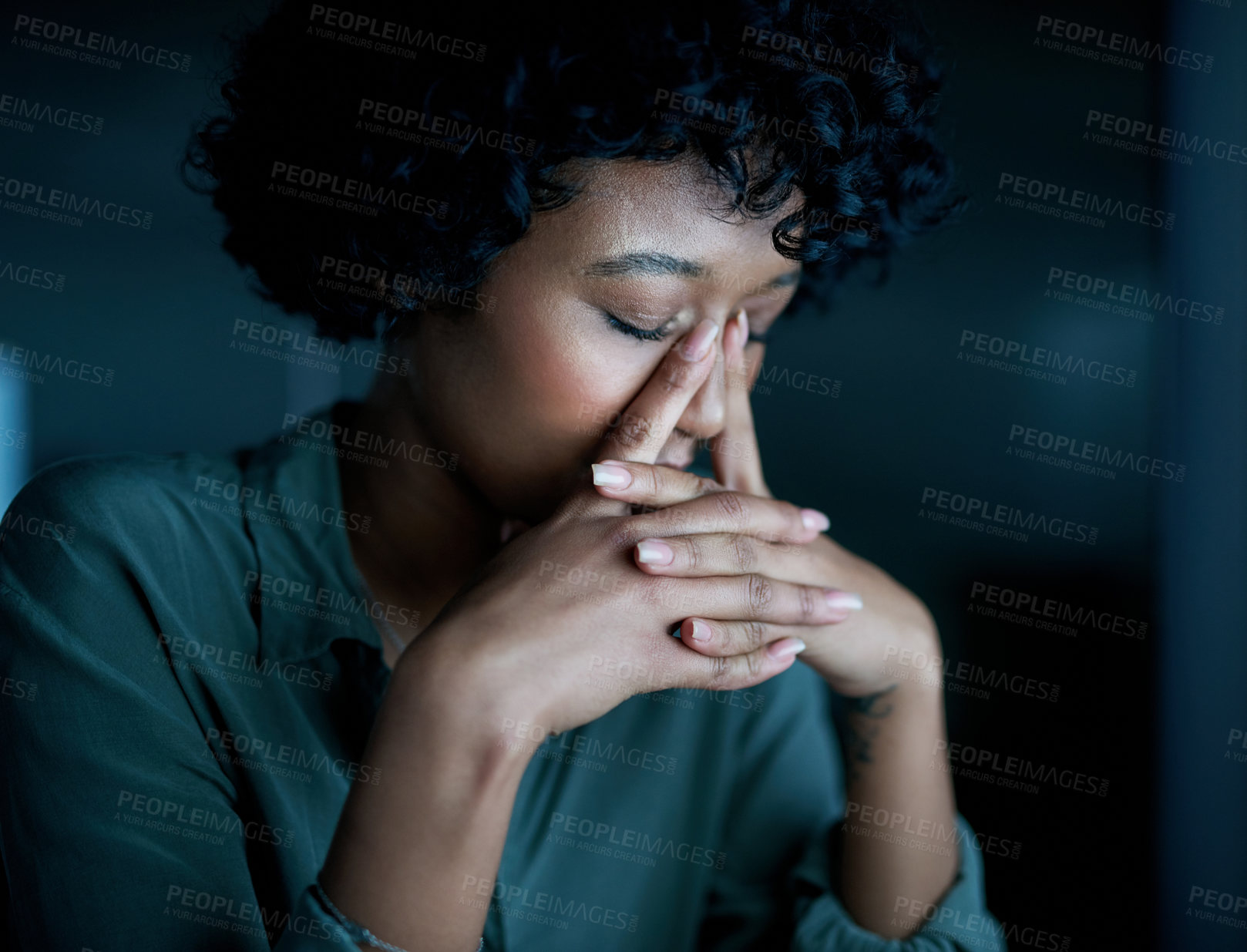 Buy stock photo Shot of a young businesswoman looking stressed during a late night at work