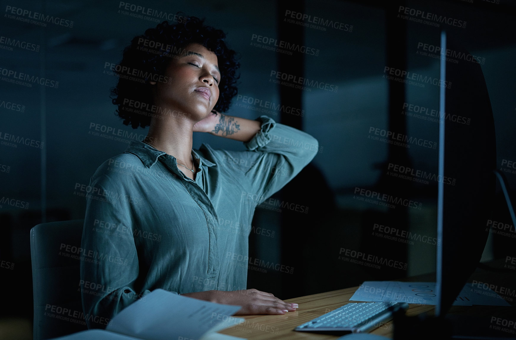 Buy stock photo Shot of a young businesswoman experiencing neck pain while using a computer during a late night at work