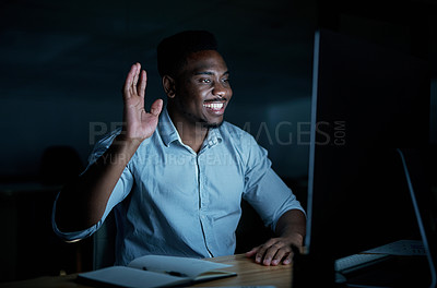 Buy stock photo Shot of a young businessman using a computer to make a video call during a late night at work