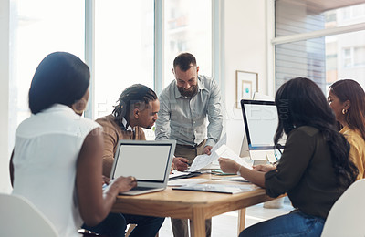 Buy stock photo Cropped shot of a diverse group of businesspeople using technology during a meeting in the office during the day