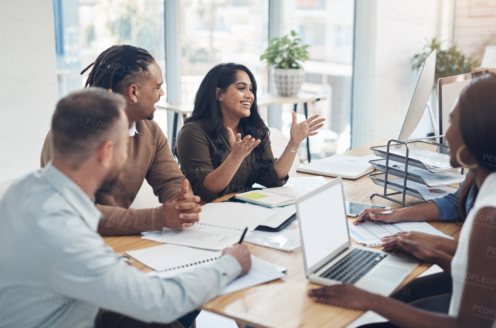 Buy stock photo Cropped shot of a diverse group of businesspeople sitting together during a meeting in the office