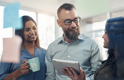 Buy stock photo Cropped shot of a diverse group of businesspeople standing together and using a glass board to brainstorm in the office