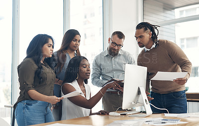 Buy stock photo Cropped shot of a diverse group of businesspeople using technology during a meeting in the office