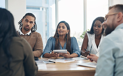 Buy stock photo Cropped shot of a diverse group of businesspeople sitting together during a meeting in the office