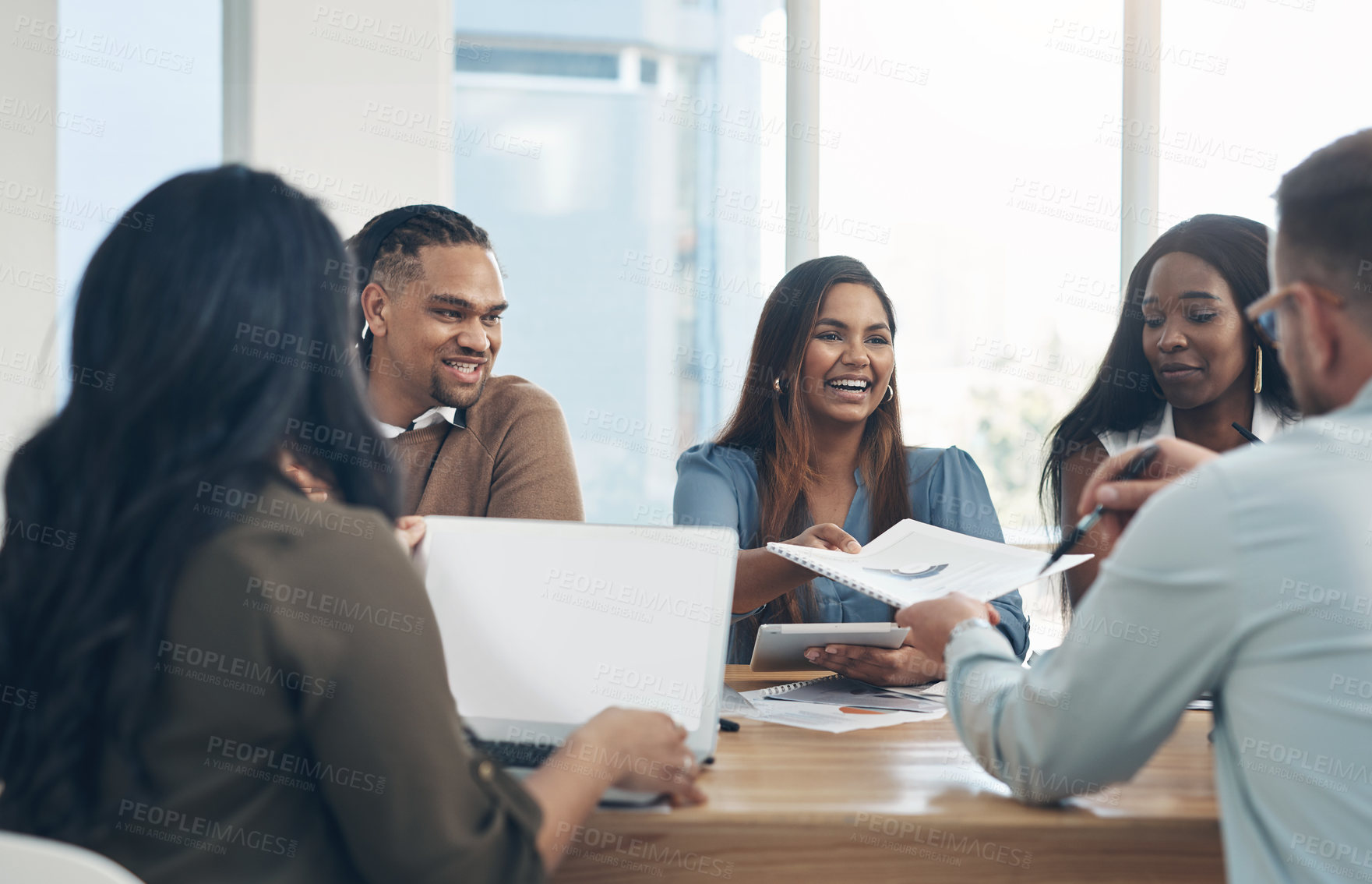 Buy stock photo Cropped shot of a diverse group of businesspeople sitting together during a meeting in the office