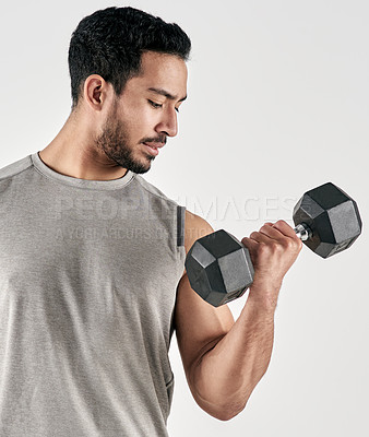 Buy stock photo Studio shot of a muscular young man exercising with a dumbbell against a white background