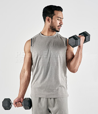 Buy stock photo Studio shot of a muscular young man exercising with dumbbells against a white background