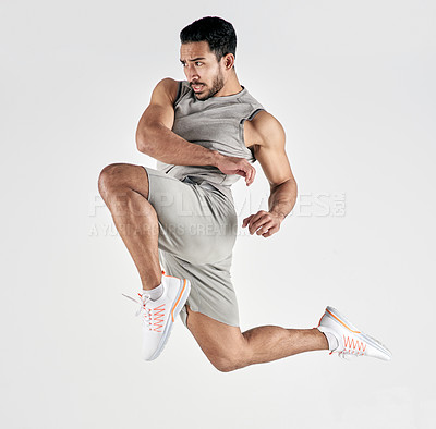 Buy stock photo Studio shot of a muscular young man jumping against a white background