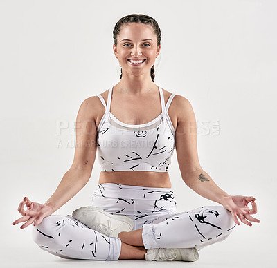 Buy stock photo Studio portrait of a sporty young woman meditating against a white background