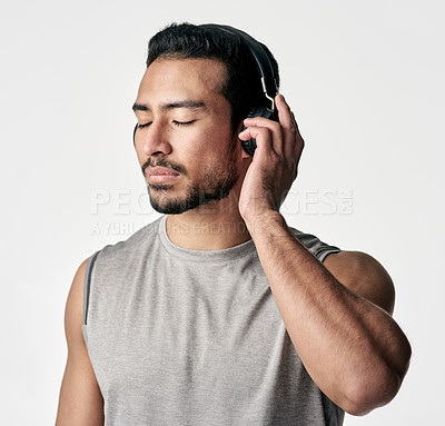 Buy stock photo Studio shot of a sporty young man wearing headphones against a white background