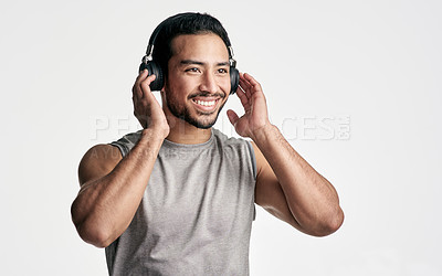 Buy stock photo Studio shot of a sporty young man wearing headphones against a white background