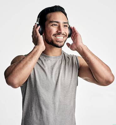 Buy stock photo Studio shot of a sporty young man wearing headphones against a white background