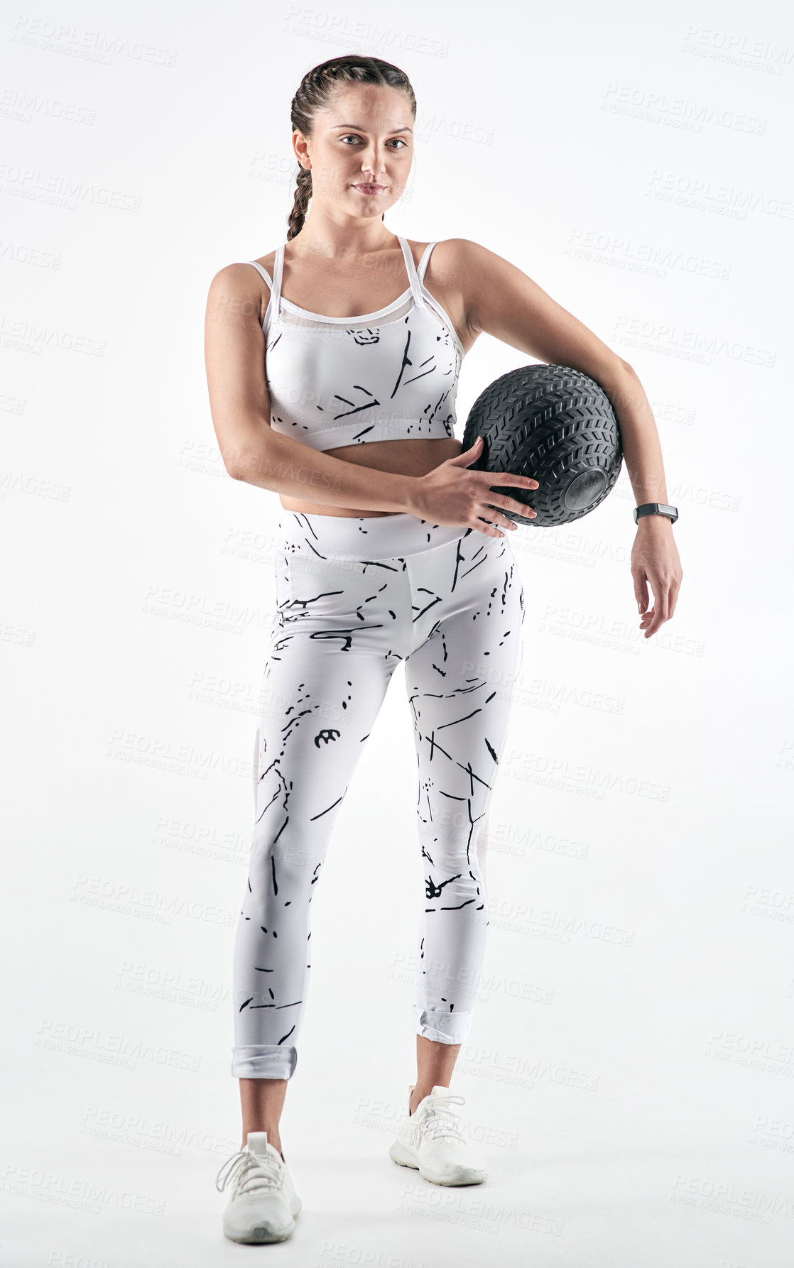 Buy stock photo Studio portrait of a sporty young woman holding an exercise ball against a white background