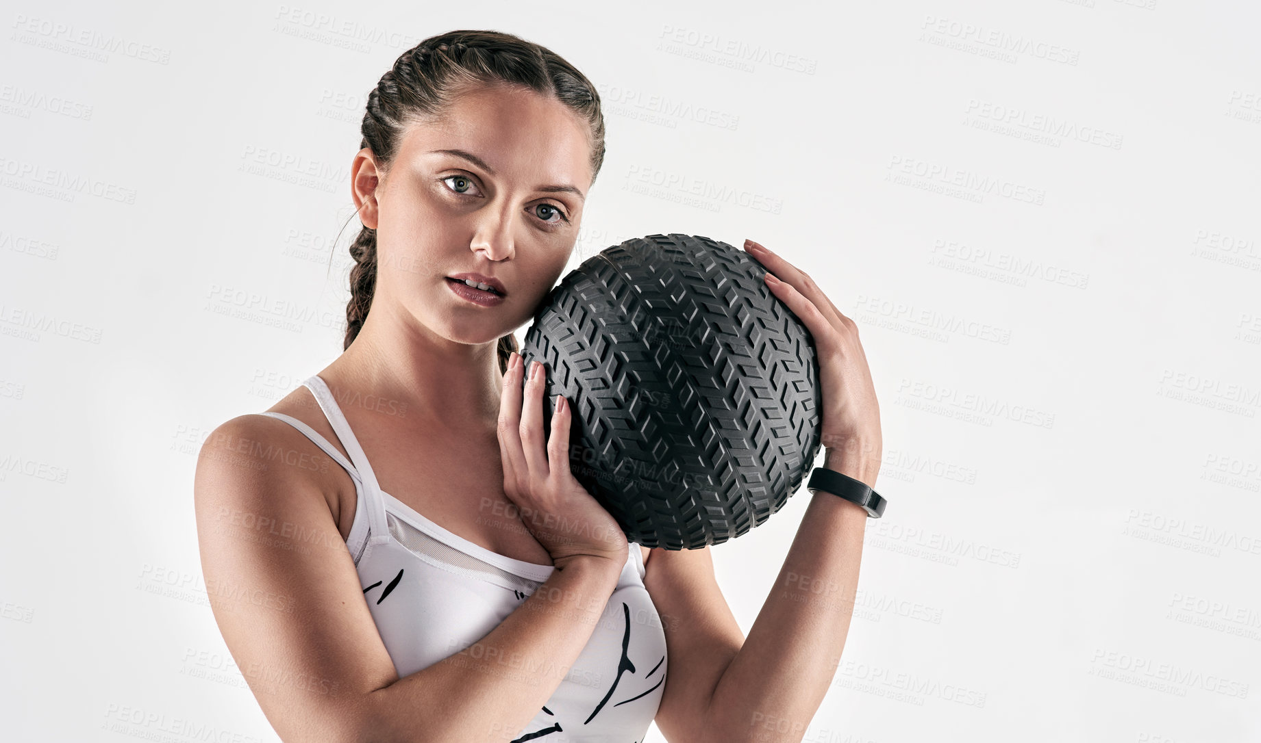 Buy stock photo Studio portrait of a sporty young woman holding an exercise ball against a white background