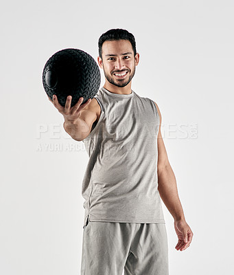 Buy stock photo Studio portrait of a muscular young man holding an exercise ball against a white background