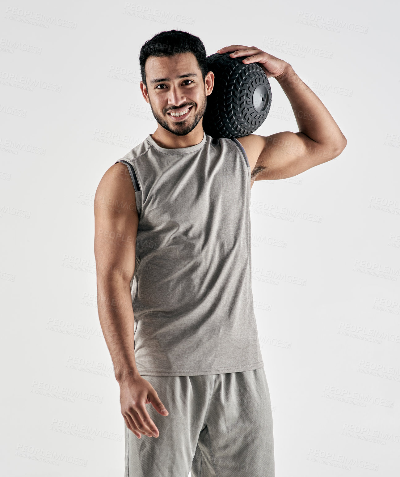 Buy stock photo Studio portrait of a muscular young man holding an exercise ball against a white background