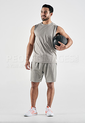 Buy stock photo Studio shot of a muscular young man holding an exercise ball against a white background