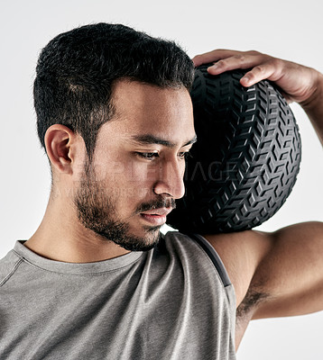 Buy stock photo Studio shot of a muscular young man holding an exercise ball against a white background