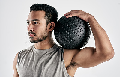 Buy stock photo Studio shot of a muscular young man holding an exercise ball against a white background