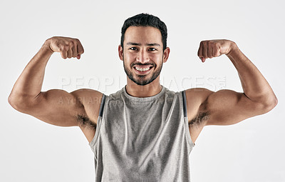 Buy stock photo Studio portrait of a muscular young man flexing his biceps against a white background