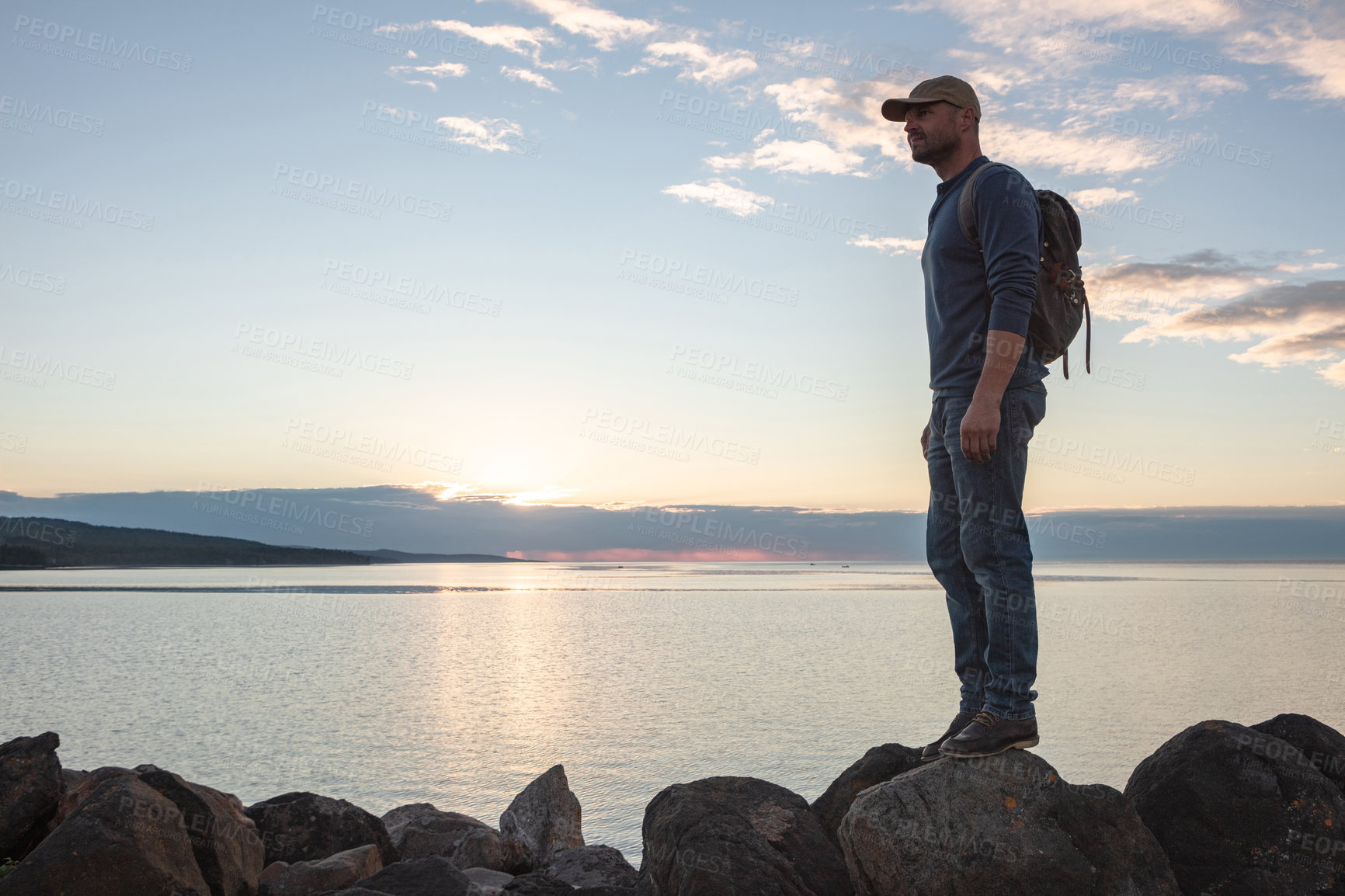 Buy stock photo Shot of a man wearing his backpack while out for a hike on a coastal trail