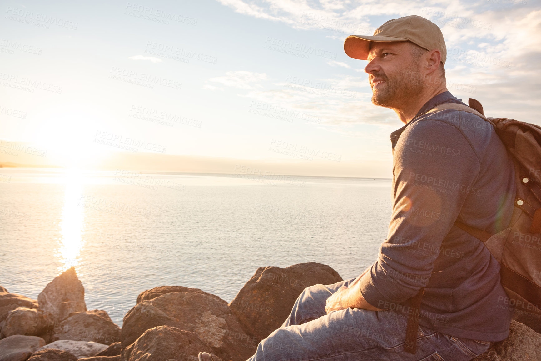 Buy stock photo Shot of a man wearing his backpack while out for a hike on a coastal trail