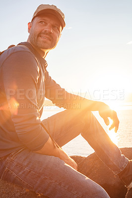 Buy stock photo Shot of a man wearing his backpack while out for a hike on a coastal trail