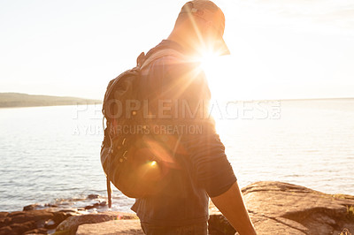 Buy stock photo Shot of a man wearing his backpack while out for a hike on a coastal trail