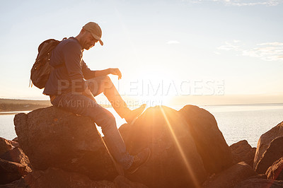 Buy stock photo Shot of a man wearing his backpack while out for a hike on a coastal trail