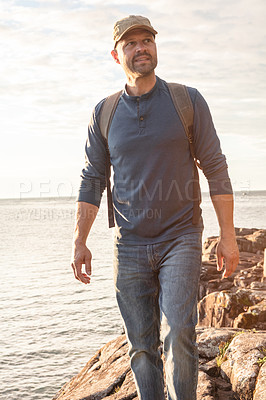 Buy stock photo Shot of a man wearing his backpack while out for a hike on a coastal trail