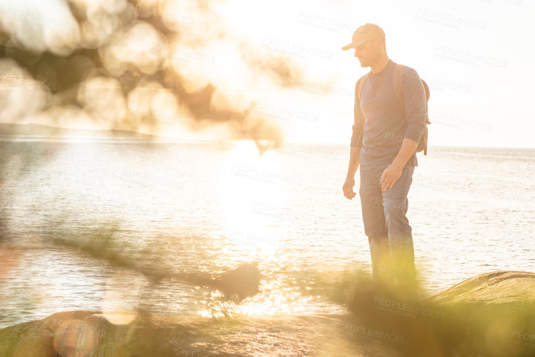 Buy stock photo Hiking, travel and ocean with man in nature for trekking adventure, backpacking and seaside trail. Trees, summer vacation and sunshine with person outdoor for sunset, explore and tourism holiday