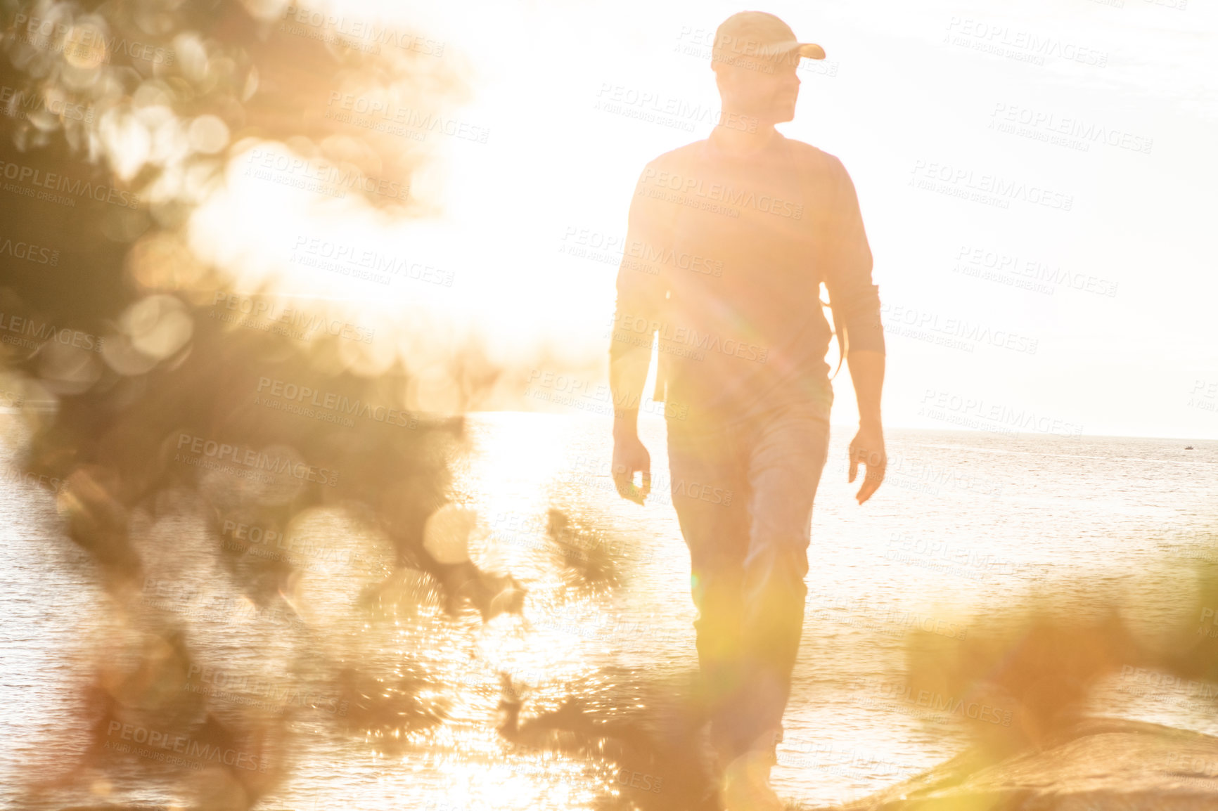 Buy stock photo Shot of a man wearing his backpack while out for a hike on a coastal trail