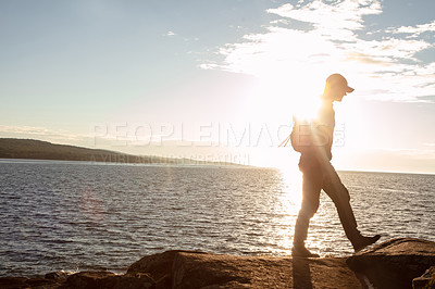 Buy stock photo Shot of a man wearing his backpack while out for a hike on a coastal trail