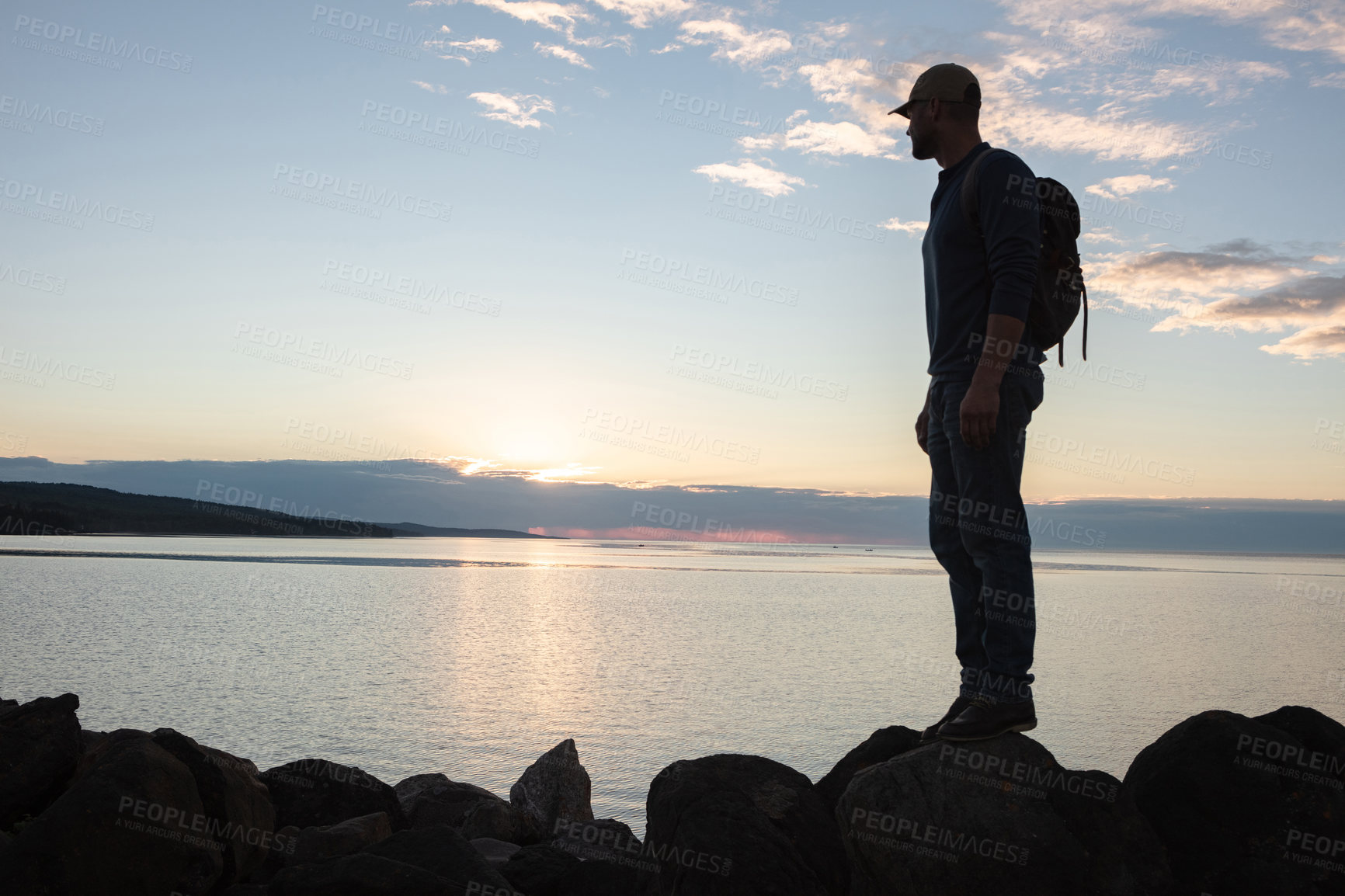 Buy stock photo Shot of a man wearing his backpack while out for a hike on a coastal trail