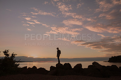 Buy stock photo Shot of a man wearing his backpack while out for a hike on a coastal trail