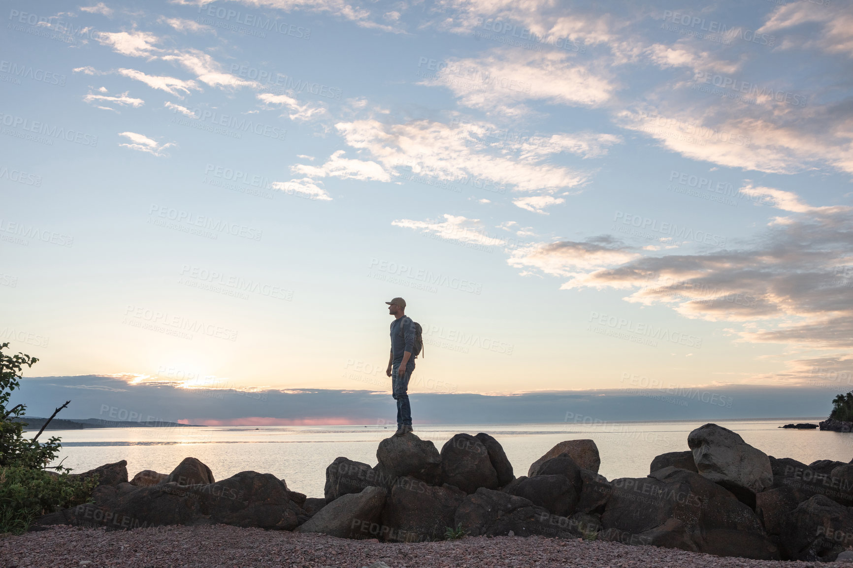 Buy stock photo Shot of a man wearing his backpack while out for a hike on a coastal trail