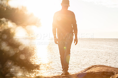 Buy stock photo Shot of a man wearing his backpack while out for a hike on a coastal trail