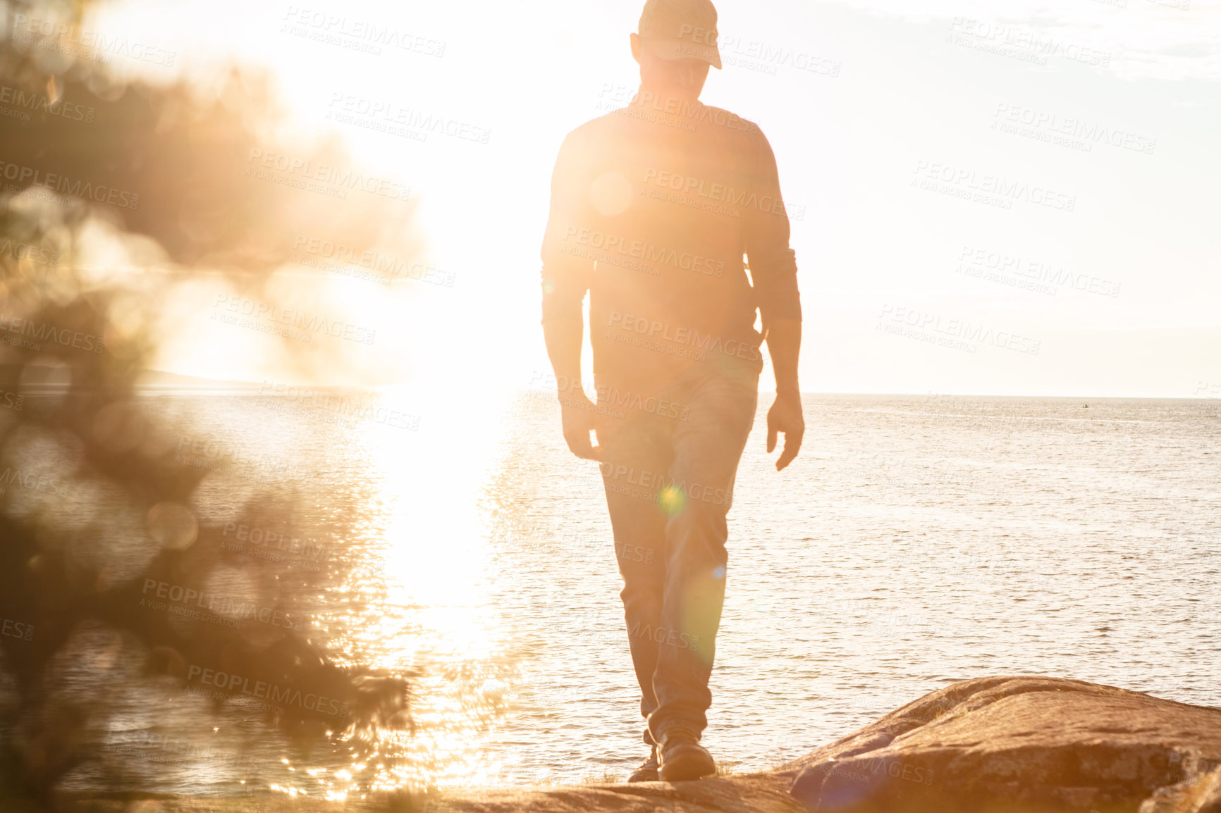 Buy stock photo Shot of a man wearing his backpack while out for a hike on a coastal trail