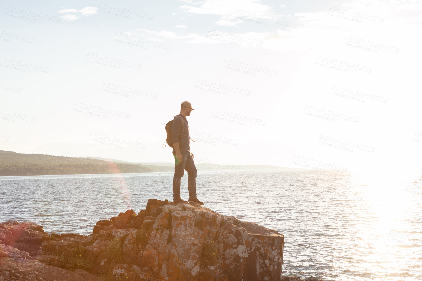 Buy stock photo Shot of a man wearing his backpack while out for a hike on a coastal trail