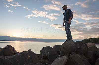 Buy stock photo Shot of a man wearing his backpack while out for a hike on a coastal trail