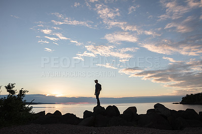 Buy stock photo Shot of a man wearing his backpack while out for a hike on a coastal trail