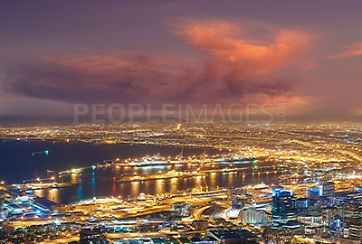 Buy stock photo Scenic view of Cape Town at night from Signal Hill in South Africa. Beautiful landscape view of the city lights and buildings against a dark and cloudy evening sky. Popular tourist town at twilight