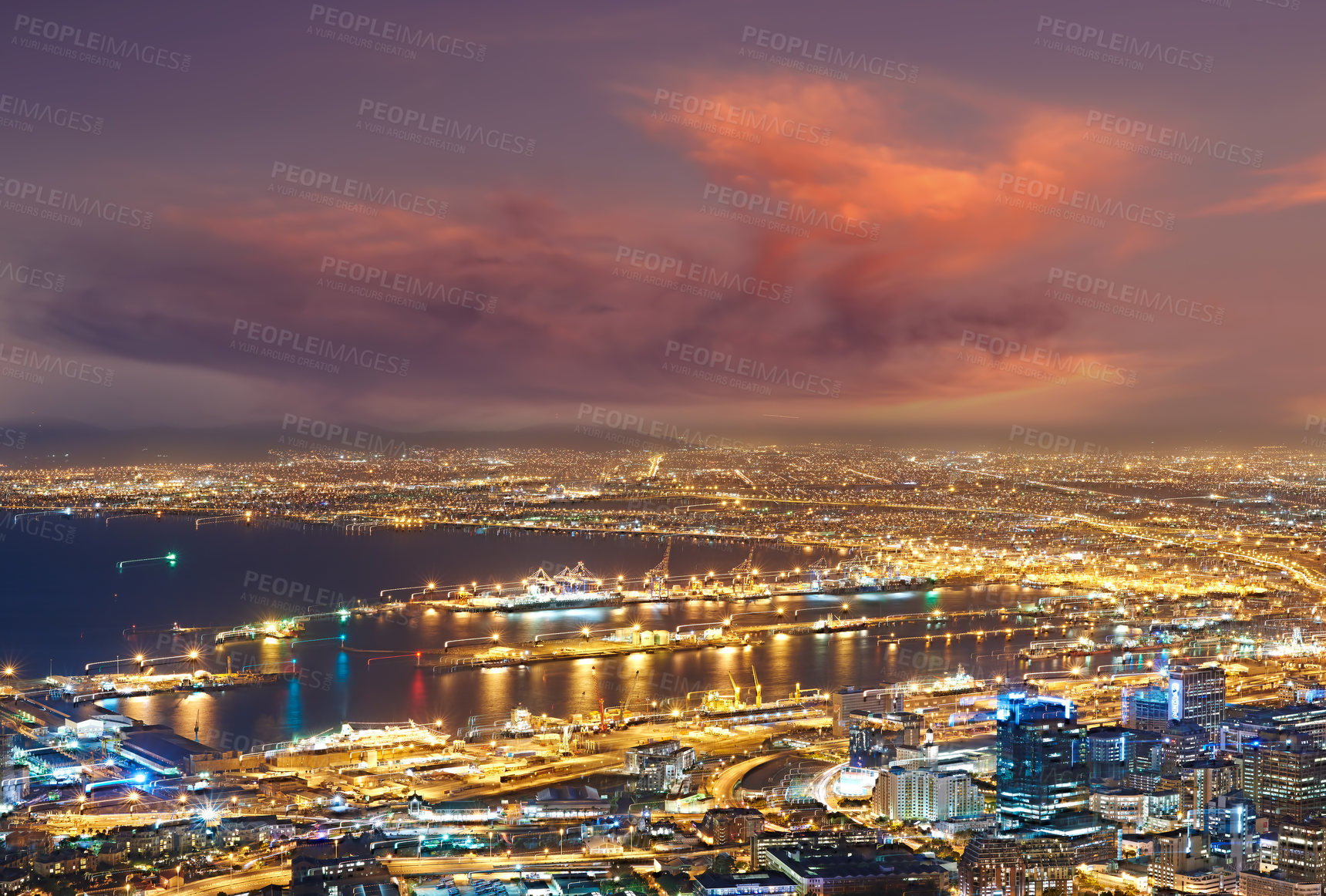 Buy stock photo Scenic view of Cape Town at night from Signal Hill in South Africa. Beautiful landscape view of the city lights and buildings against a dark and cloudy evening sky. Popular tourist town at twilight